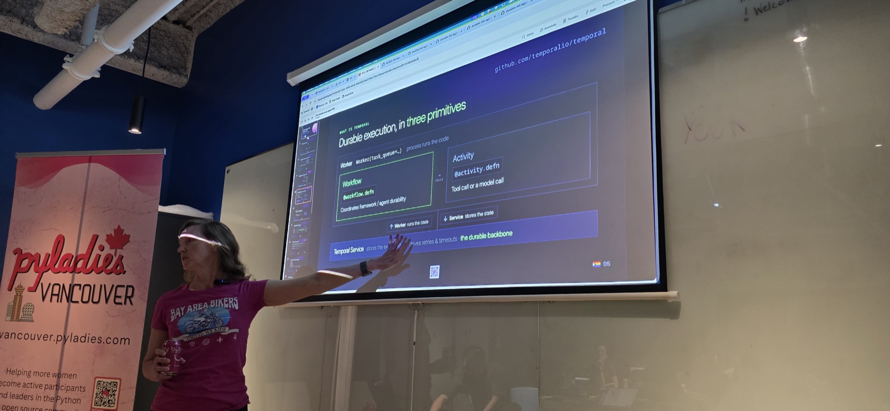 Melanie Warrick presenting in front of a projected slide titled “Durable execution, in three primitives”